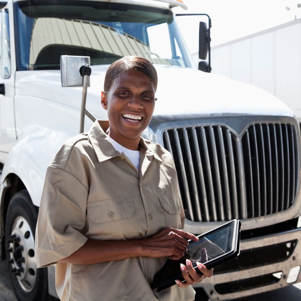 Female truck driver by big rig with digital tablet